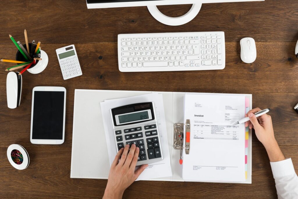 Workspace with calculator, invoice, and keyboard