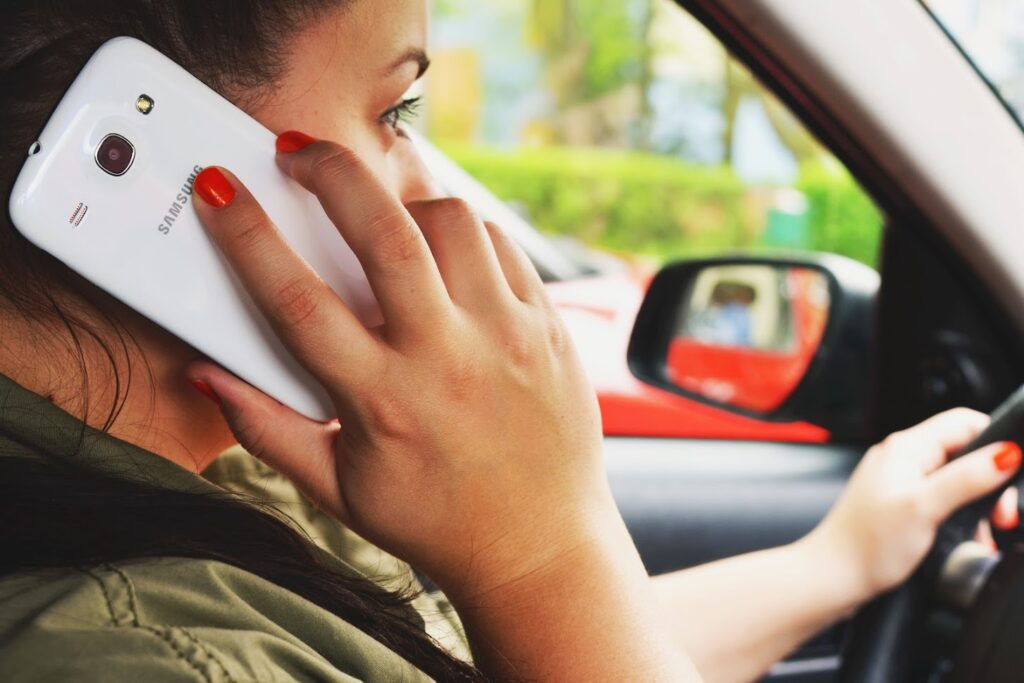 A woman talking to someone on her phone while driving