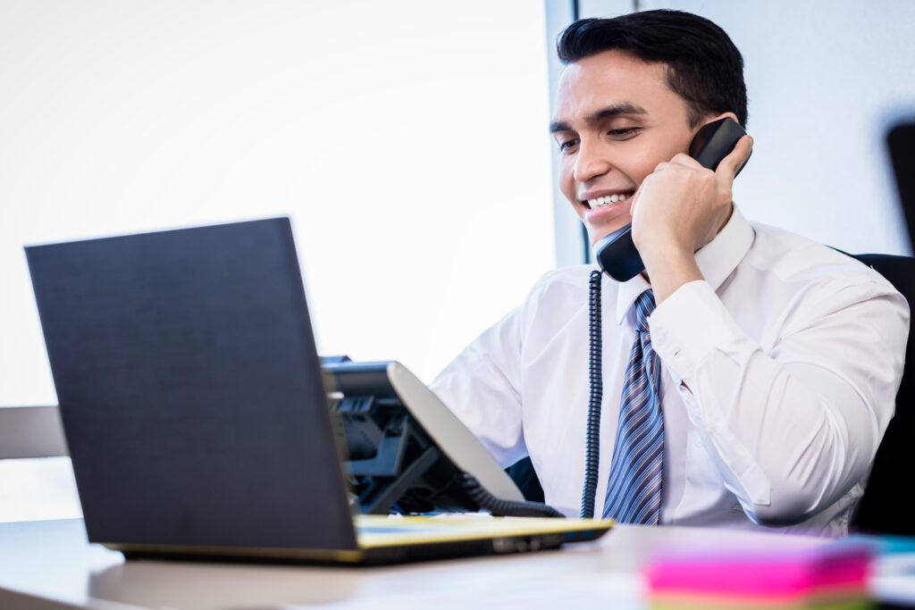 Smiling businessman on phone at desk